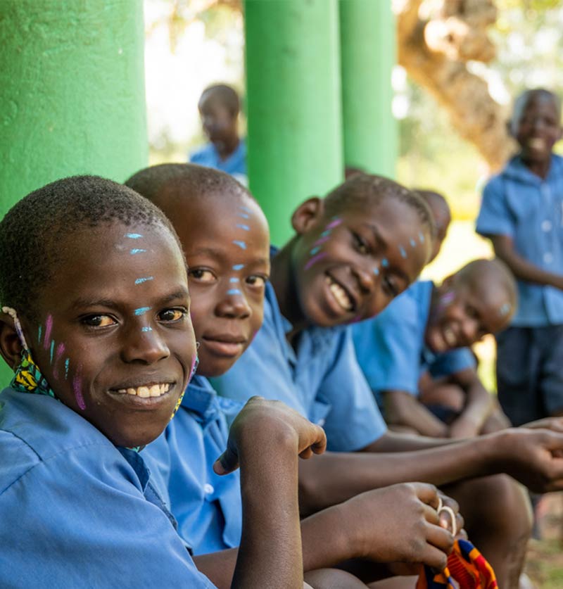 A group of a African schools students smiles towards camera