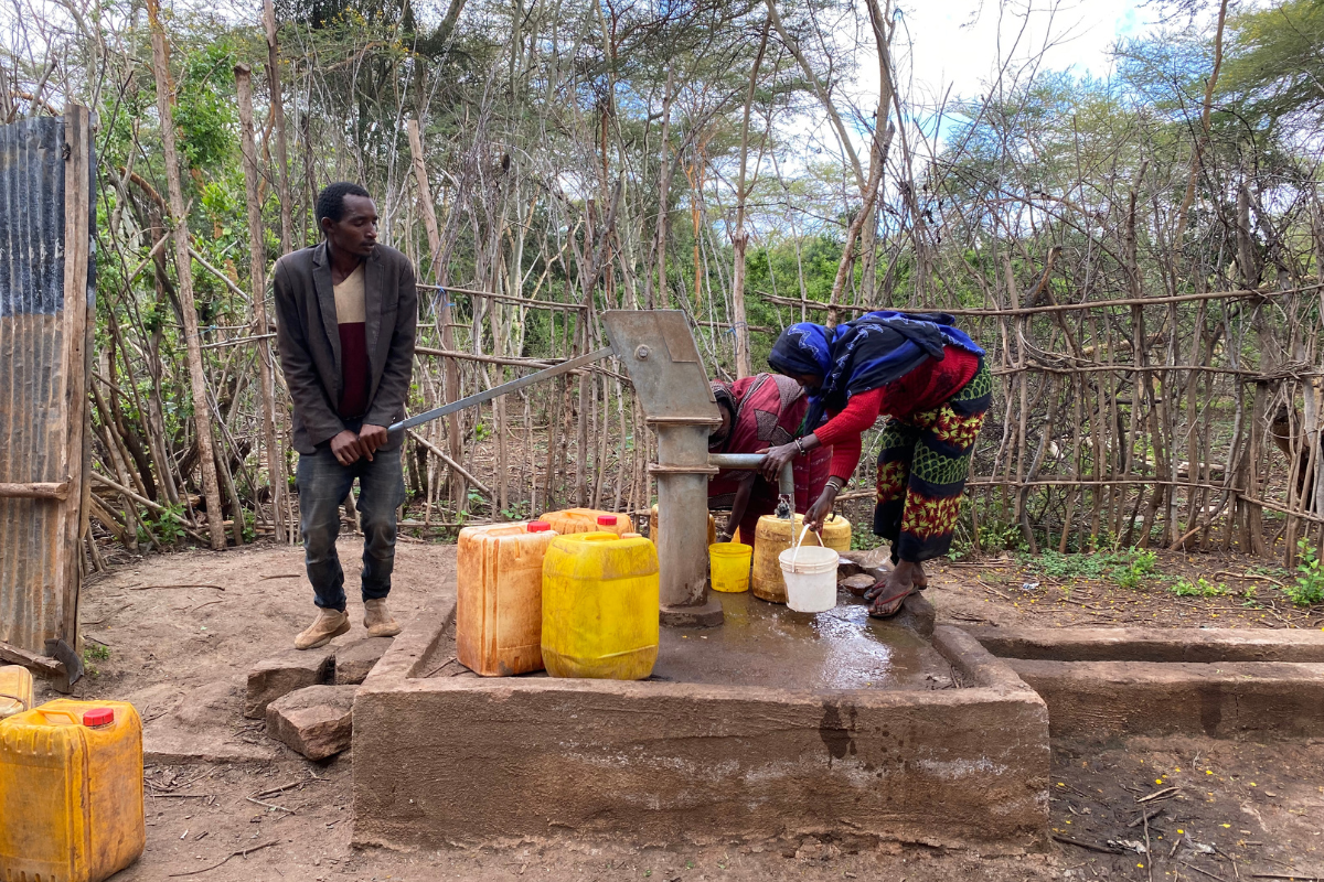 Ethiopian man hand pumping water out of a well that Petros Network partners funded in Southern Ethiopia.