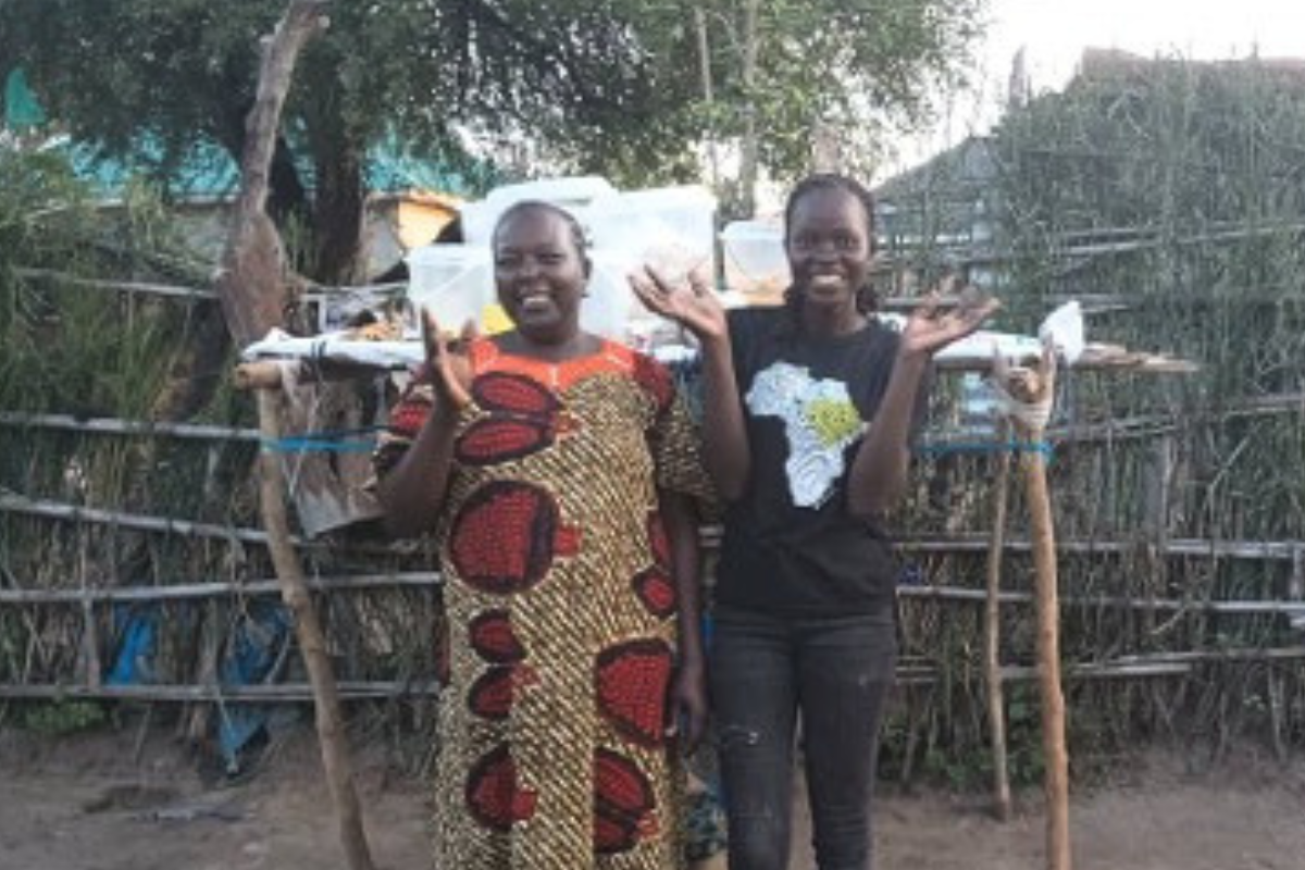 Women gathered for a Petros Network savings group meeting in Morwari Village, South Sudan, counting contributions from the community savings box.