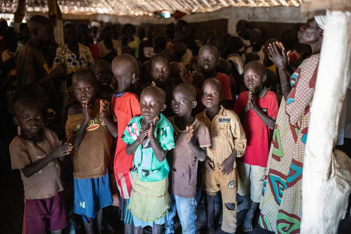 African children in a rural church in East Africa looking up at the camera looking ragged.