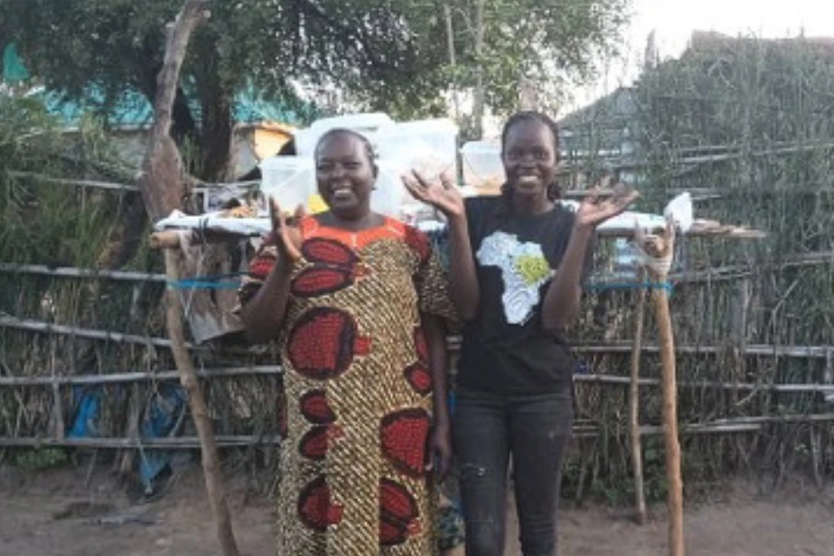 Women gathered for a Petros Network savings group meeting in Morwari Village, South Sudan, counting contributions from the community savings box.